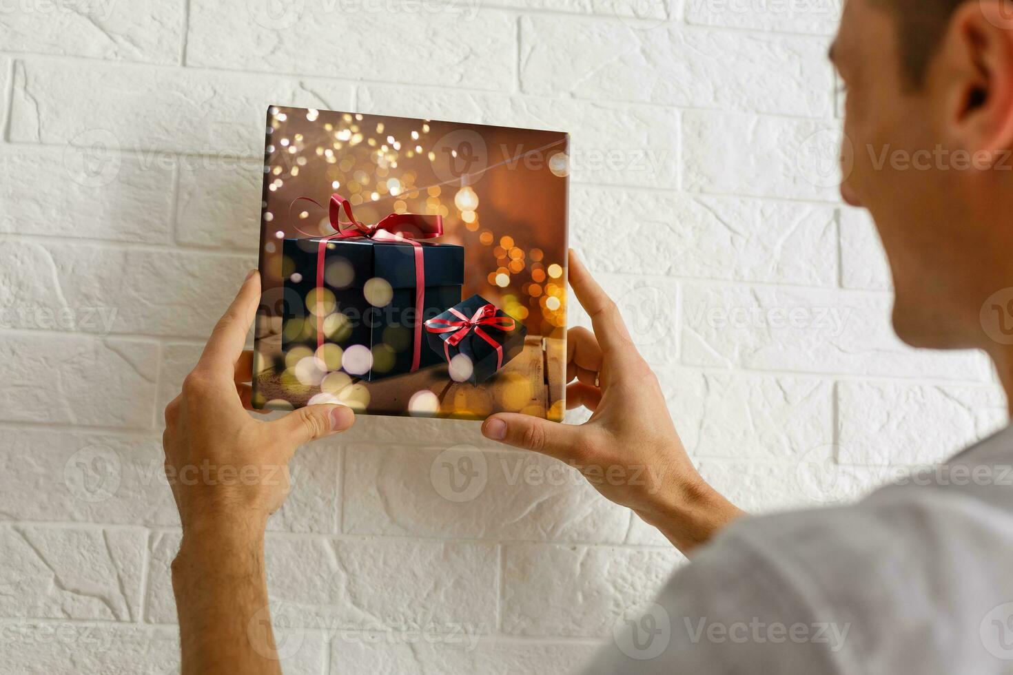 man holds photo canvas at home