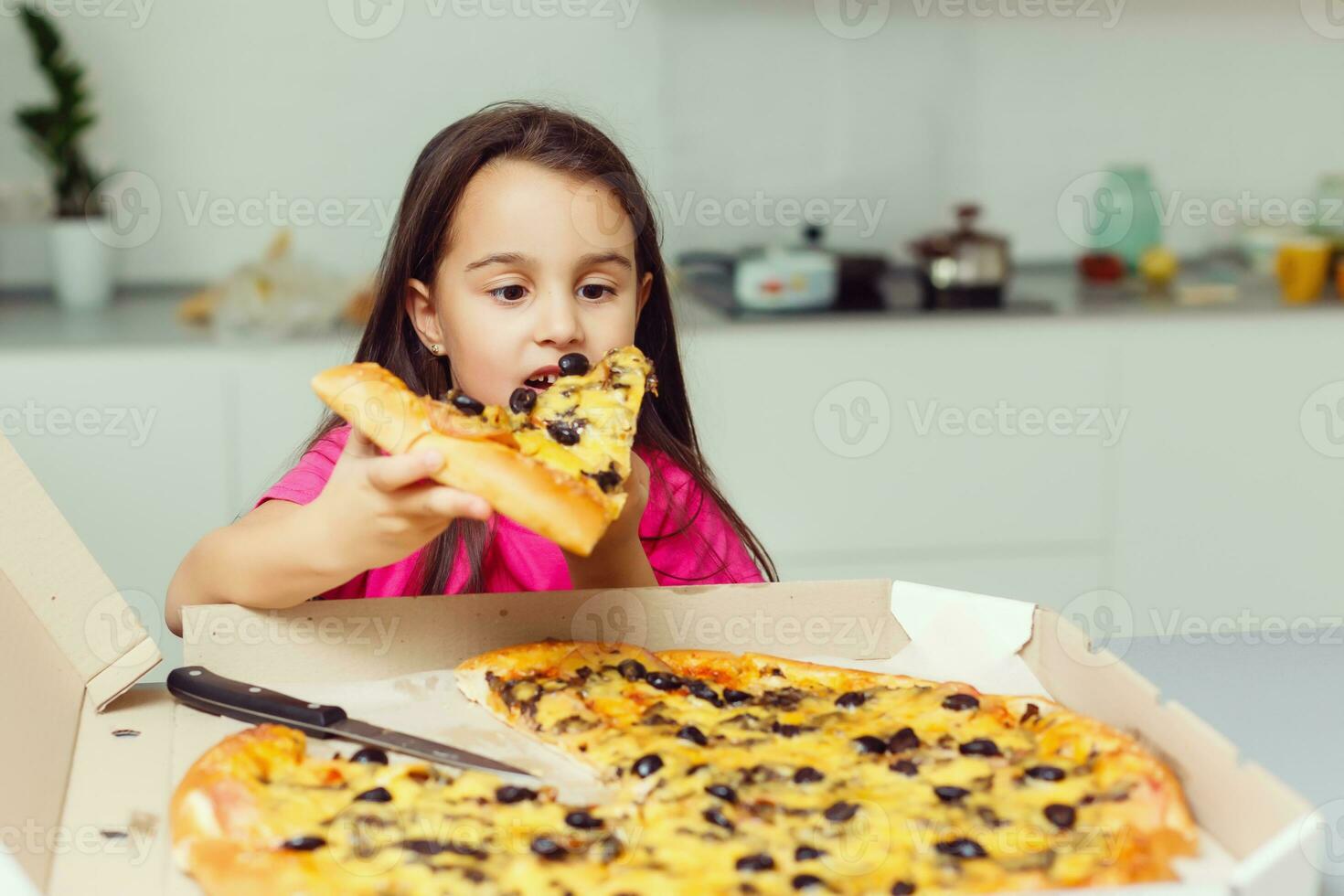 little girl with big pizza at home photo