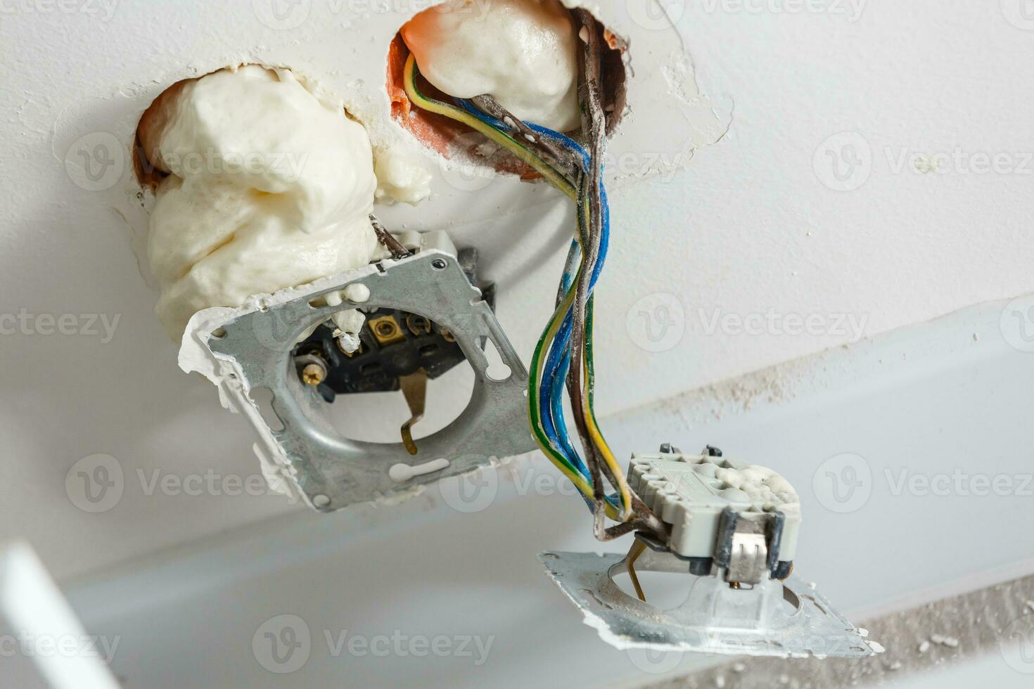 Two sockets during installation without cover. During the repair. open wires. European socket without cover isolated on white background. Professional installation of electric sockets photo