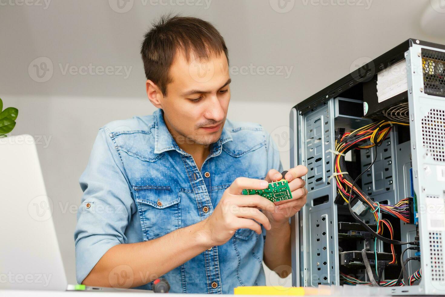 joven técnico trabajando en roto computadora en su oficina foto