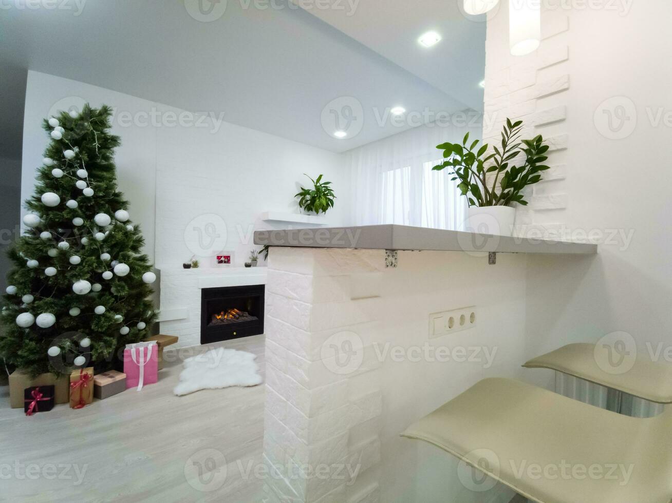 Fireplace and Christmas tree with presents in living room photo