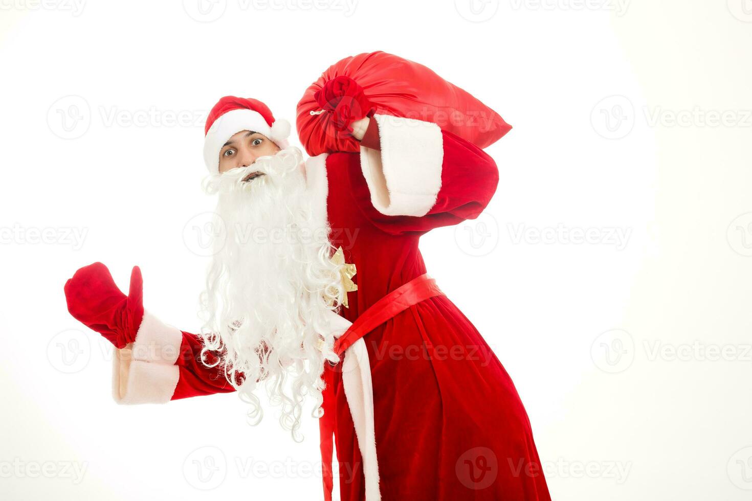 Papa Noel claus en pie arriba en blanco antecedentes con su bolso lleno de regalos foto