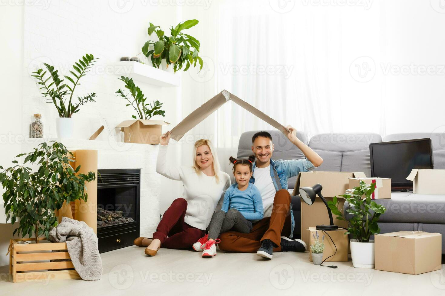 Happy family sitting on wooden floor. Father, mother and child having fun together. Moving house day, new home and design interior concept photo