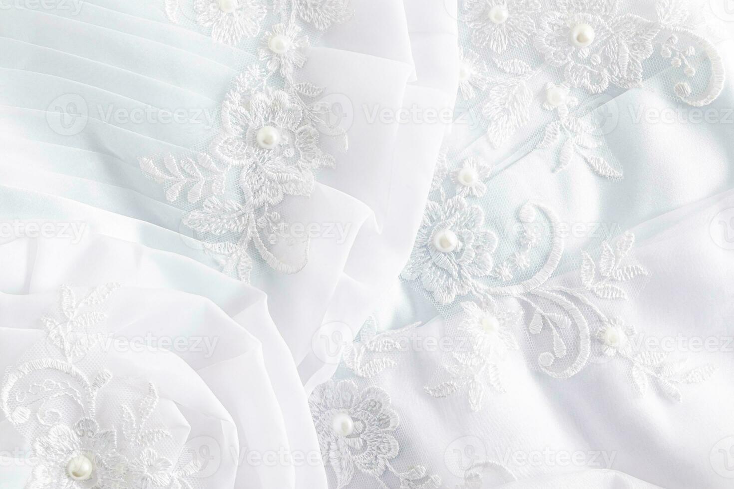 el tela detalles de el de la novia vestido, el hermosa bordado y pañería. blanco aireado pliegues de seda tela. bordado con perlas foto