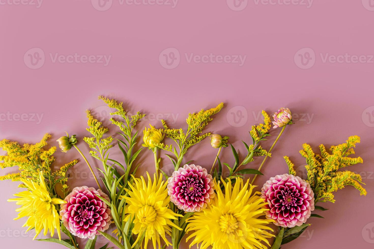 A beautiful autumn composition with bright autumn colors of yellow and purple with a copy space. Autumn festive background. Top view. Flat lay. photo