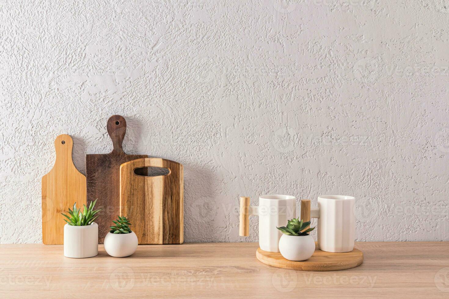 Beautiful kitchen background in a minimalist style with two stylish ceramic mugs and a set of different wooden cutting boards. front view. photo