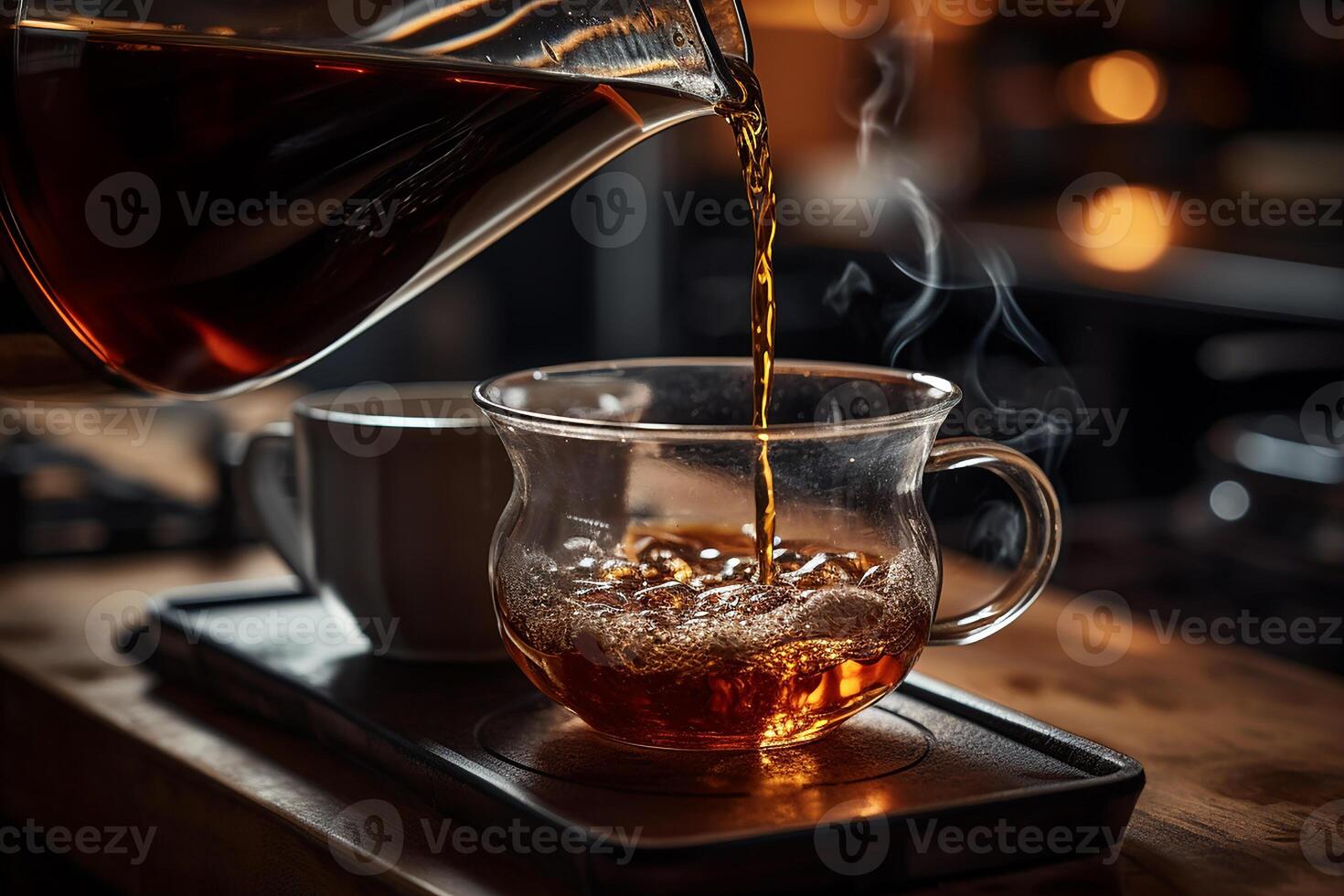 Hot Americano Drink from Clear Teapot is Poured Into a Cup in Kitchen photo
