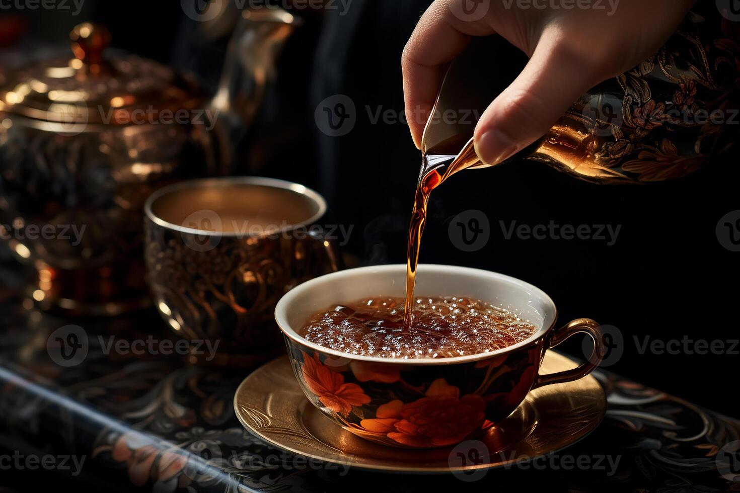 Hand Pouring Hot Tea From Teapot Into a Luxury Motif Cup photo