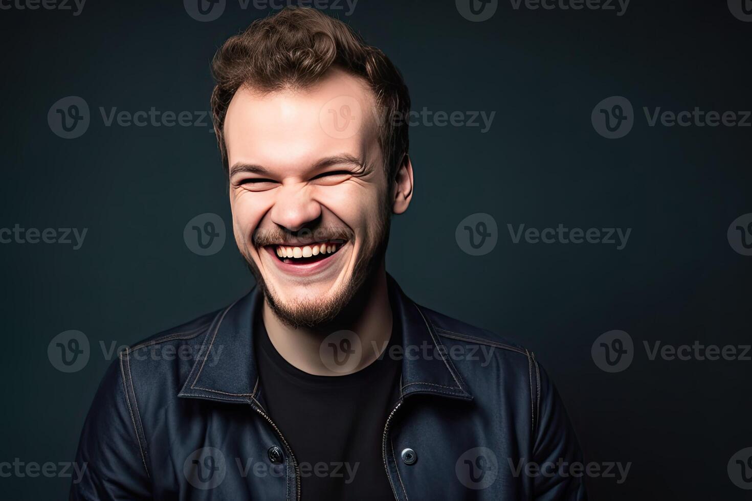 a man is laughing and smiling in a black jacket photo