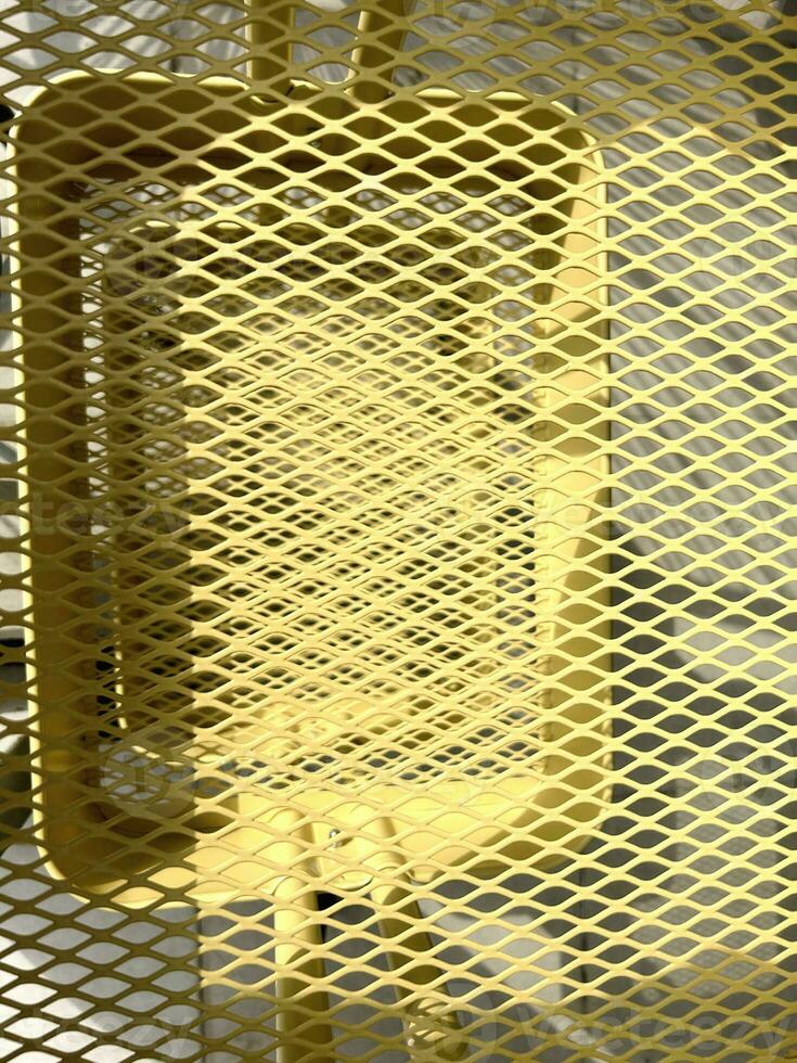 Trendy protective yellow lattice. Diamond-shaped metallic modern grid. Abstract yellow background. Geometric backdrop. Vertical composition. Mesh geometric. High quality photo. photo