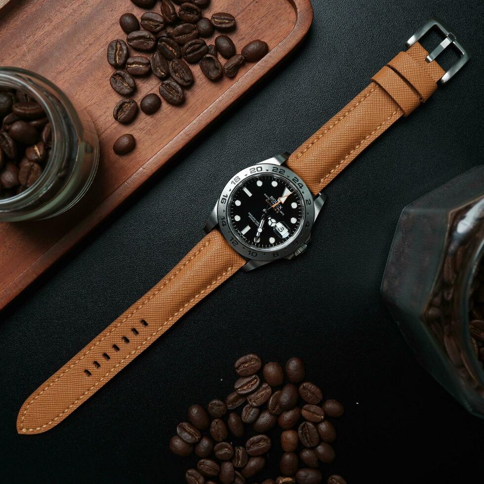 Surabaya, IDN, 2023 - A luxury watch with a brown leather strap, on a dark background and accessory is a jar filled with coffee beans photo