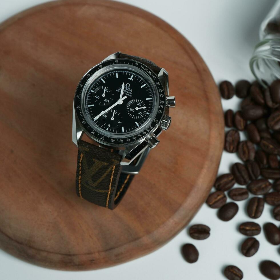 Surabaya, IDN, 2023 - Photography of luxury watch with black dial and leather strap with fashion theme, against wood and coffee bean background photo