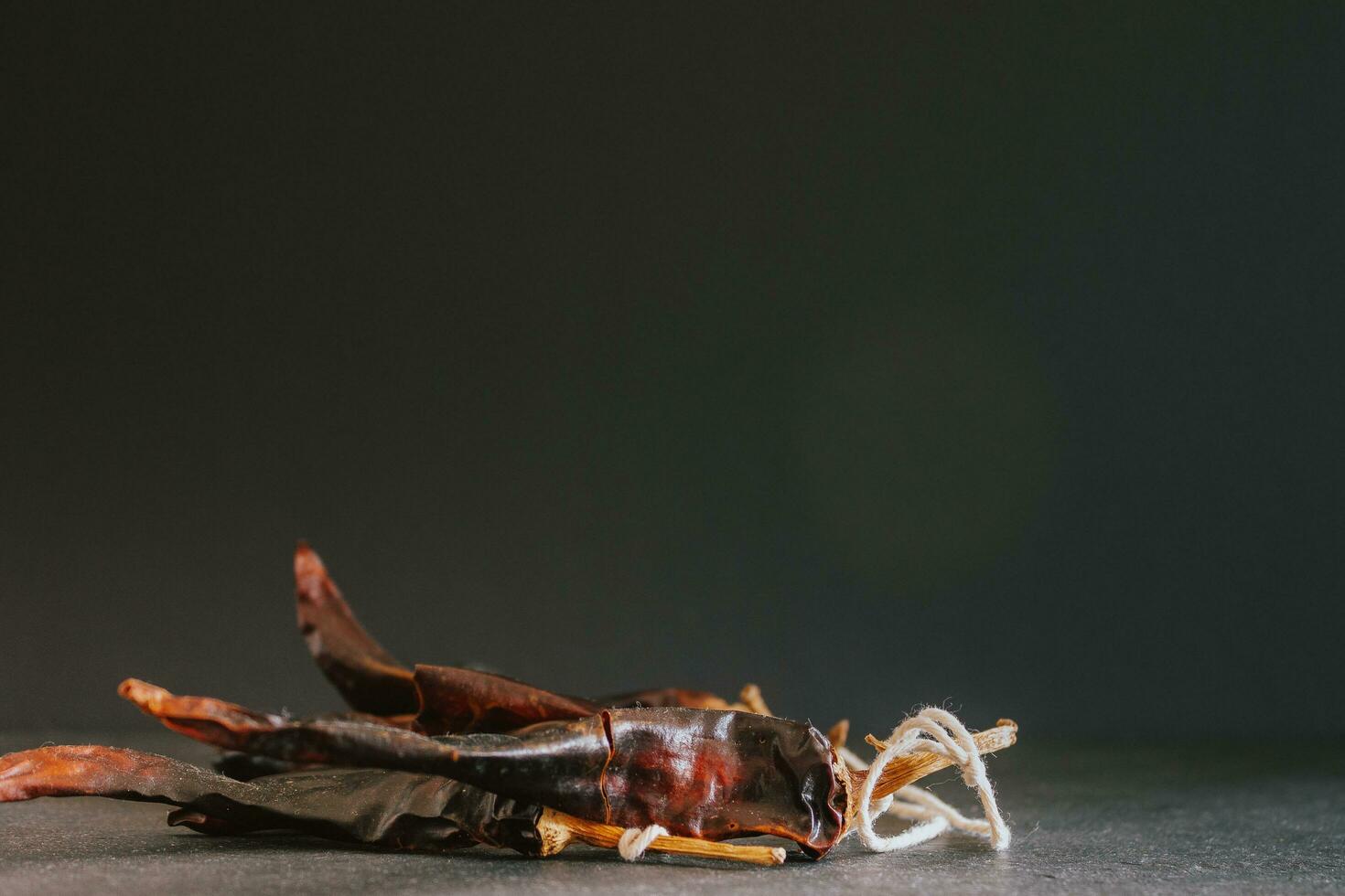 Hot chilli pepper on black background with rustic cloth, vintage tablecloth. Spicy traditional with copyspace. photo