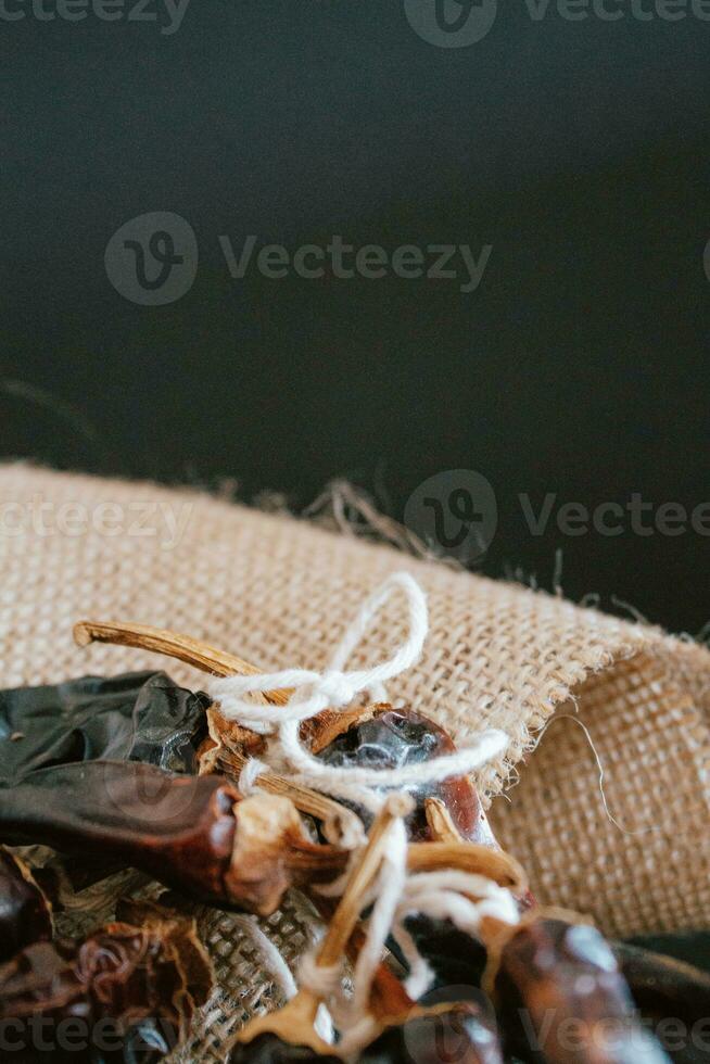 Hot chilli pepper on black background with rustic cloth, vintage tablecloth. Spicy traditional with copyspace. photo