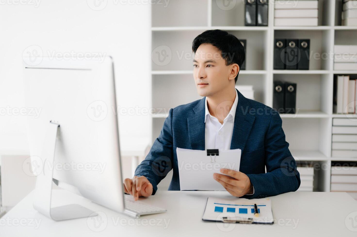 Business man using tablet and laptop for doing math finance on an office desk, tax, report, accounting, statistics, and analytical research concept in office photo