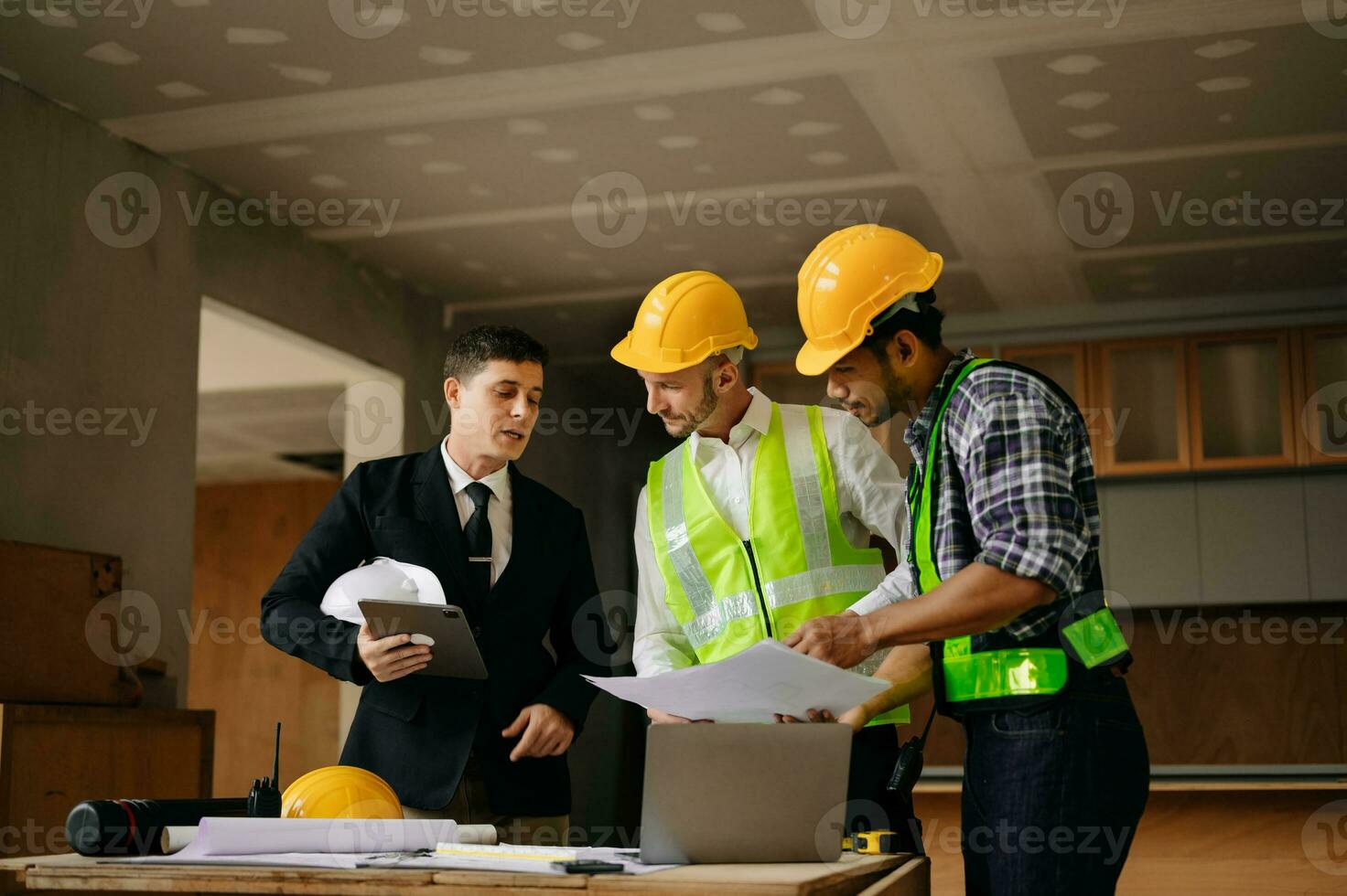Engineers are discussing data working and laptop or tablet with architectural project at new construction site on big project. interior photo