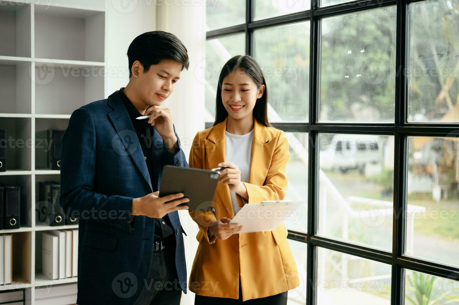 Two  Asian business  man and woman workers talking on the smartphone and using laptop Professionals in Teamwork  Finance, Marketing, and Success photo