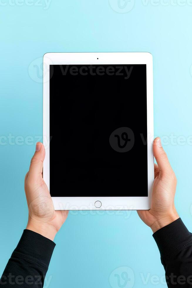 Hand holding tablet with mockup blank screen isolated on blue background. ai generated photo