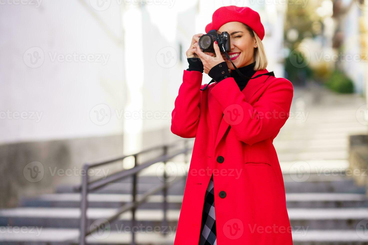 Elegant woman taking picture on street with red clothes. photo