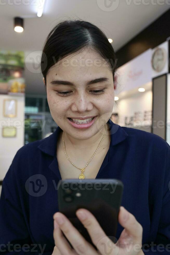 Person using phone, woman using mobile phone at home photo