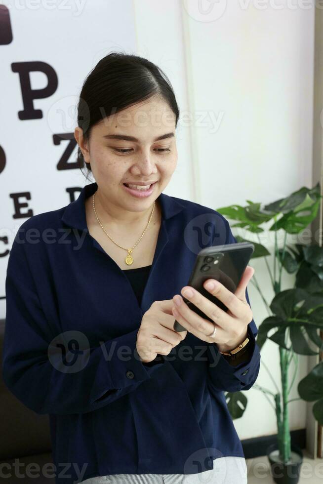 Person using phone, woman using mobile phone at home photo