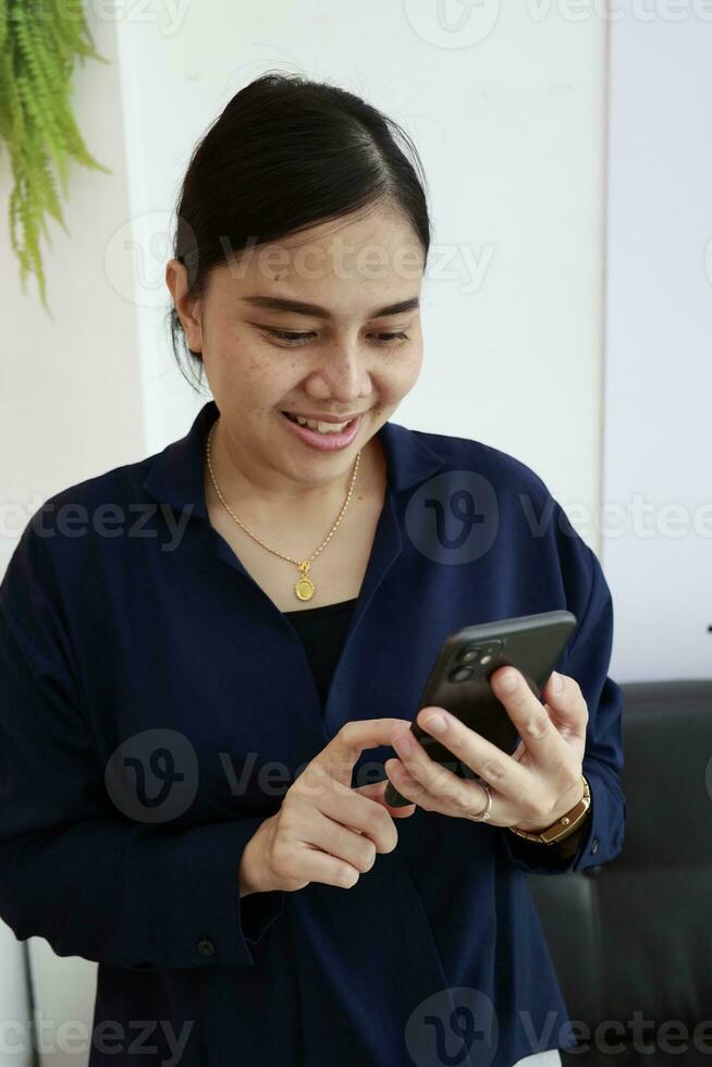 Person using phone, woman using mobile phone at home photo