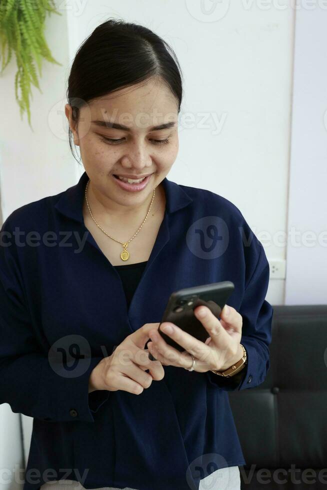 Person using phone, woman using mobile phone at home photo