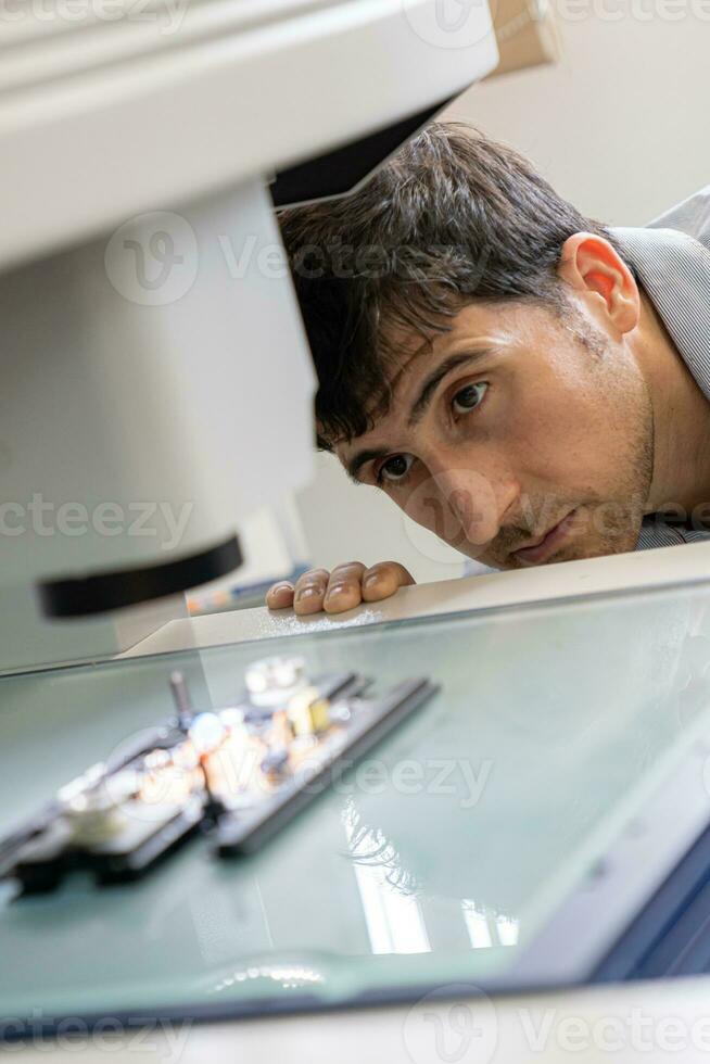 tecnología concepto un hombre en el trabajo ingeniero panel tablero ic electrónico microscopio a trabajo con un pastilla. electrónica investigación laboratorio. fabricar de papas fritas. equipo para pruebas foto