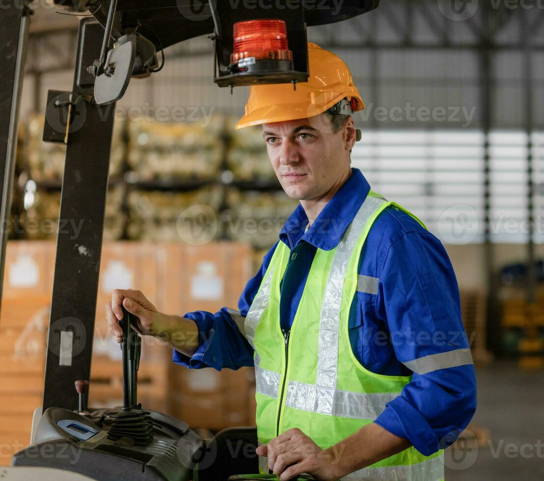 Industrial worker driving a forklift in the factory. Engineer is working and maintaining in the warehouse. photo