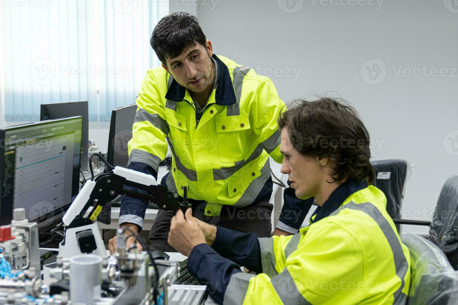 Two male automation machine engineer students studying training Programmable logic controller Technical Industrial Engineer control robotics with monitoring system software, Automation robot arm. photo