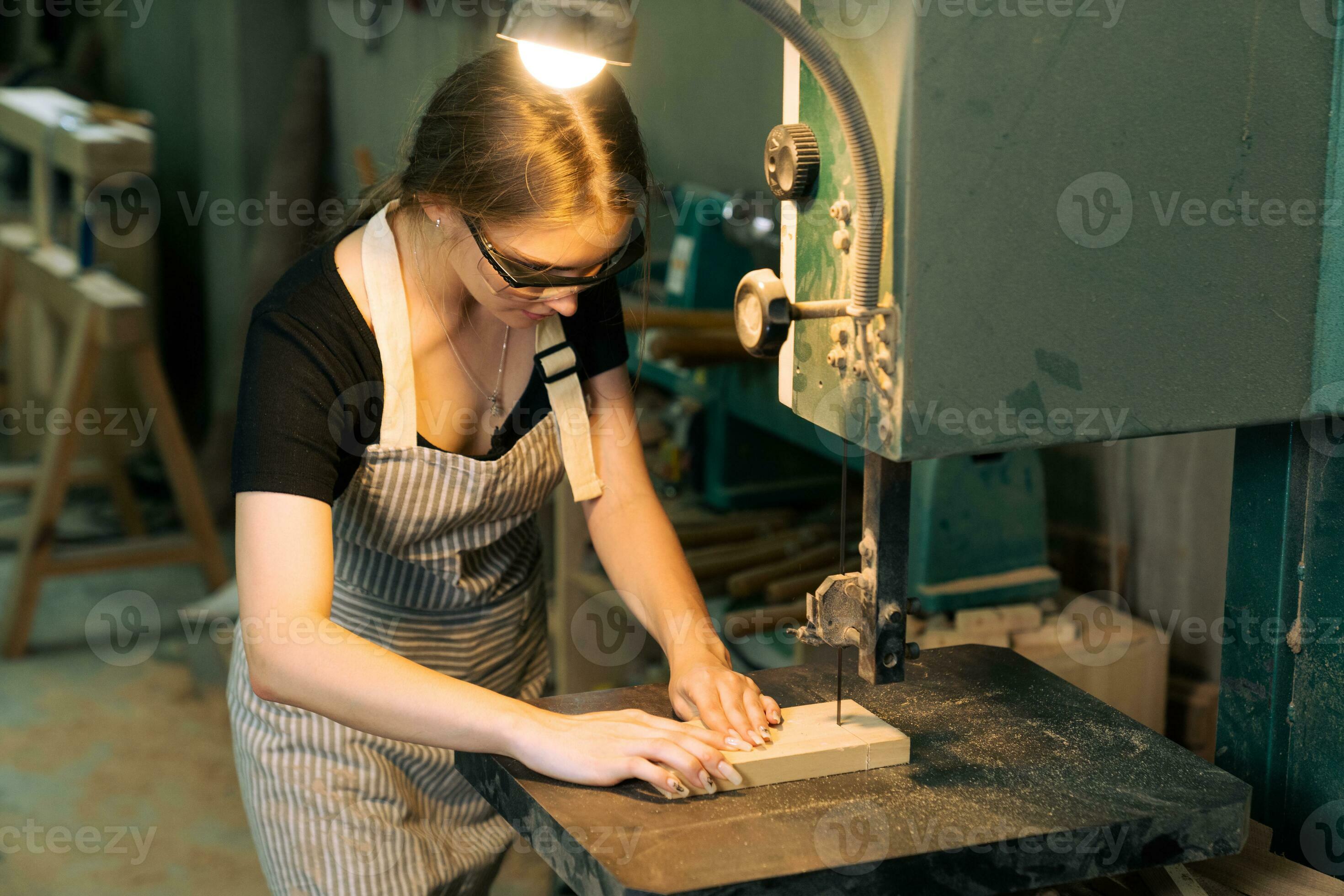 Young beautiful carpenter woman working with wood plank, a female craft