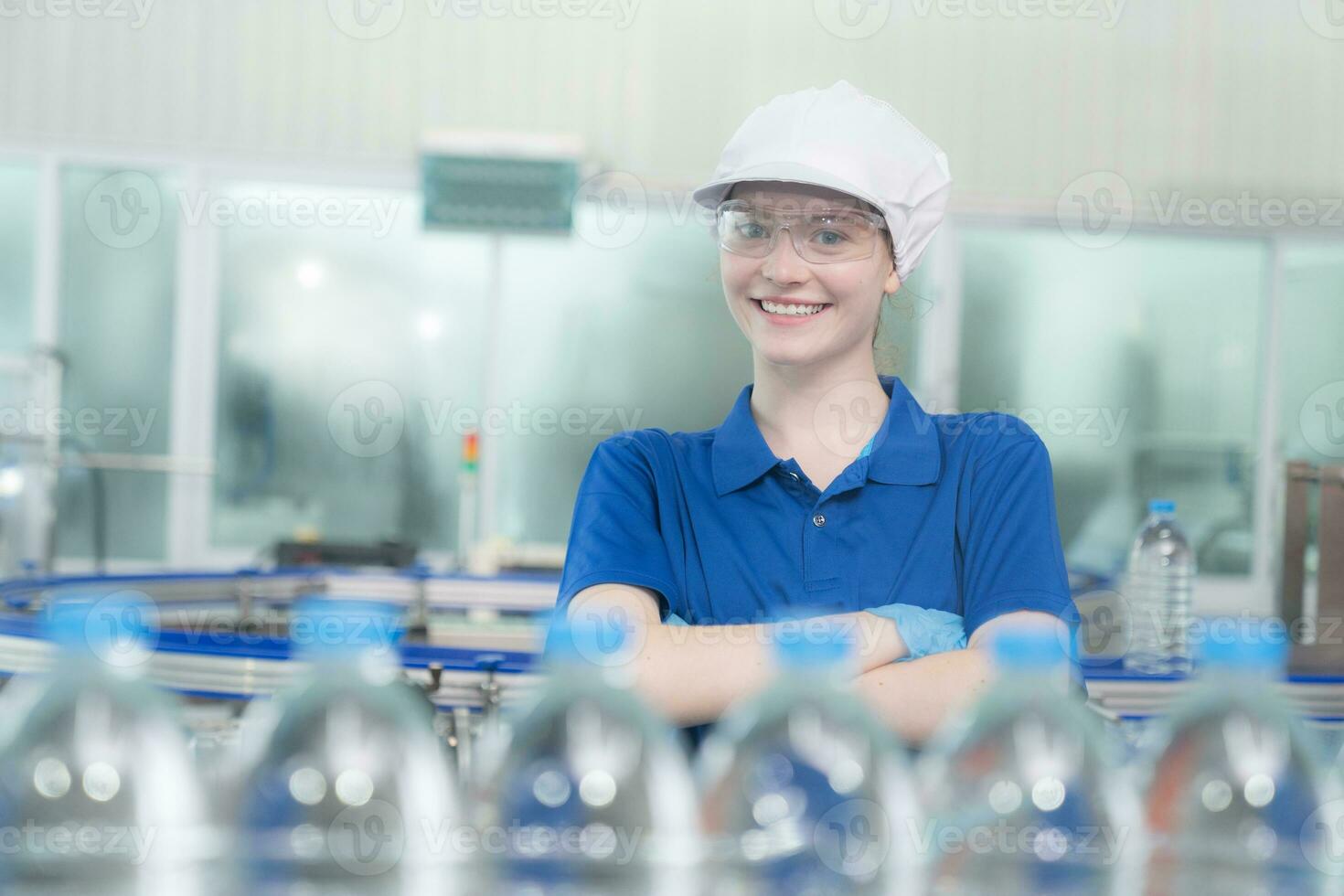 Portrait of smiling Caucasian technologist expert standing by automated machine for PET water production in a bottling factory. photo