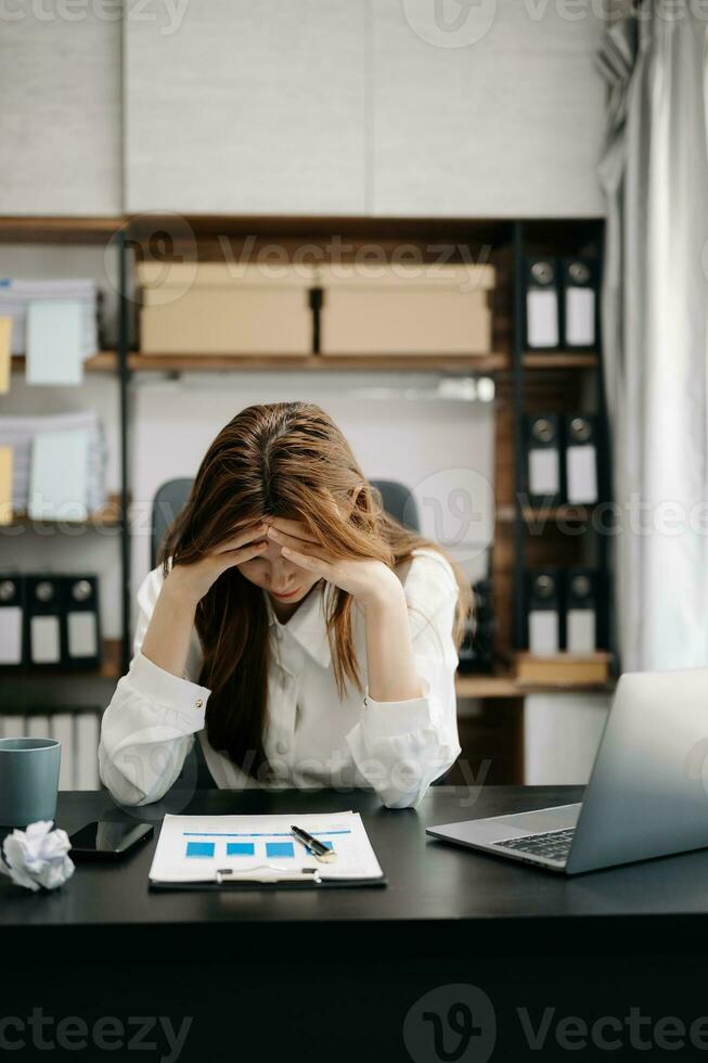 Asian business woman is stressed, bored, and overthinking from working on a tablet at the office. photo