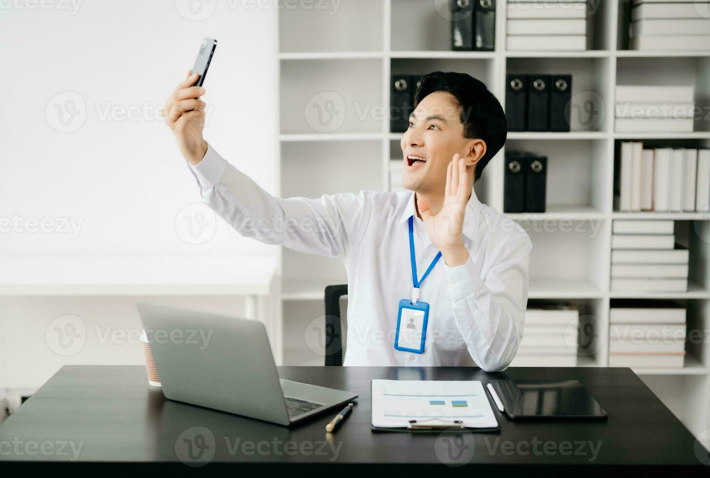 Happy asian businessman have the joy of talking on the smartphone, tablet and laptopon the office photo