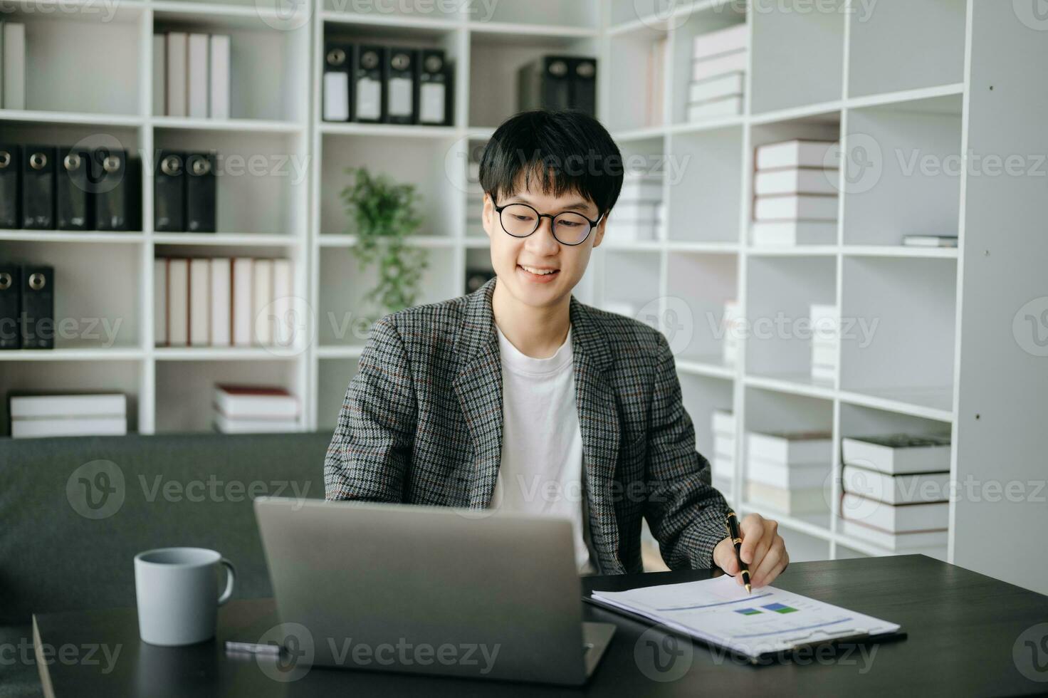 Young business man executive manager looking at laptop watching online webinar training or having virtual meeting video conference doing market research working in office. photo