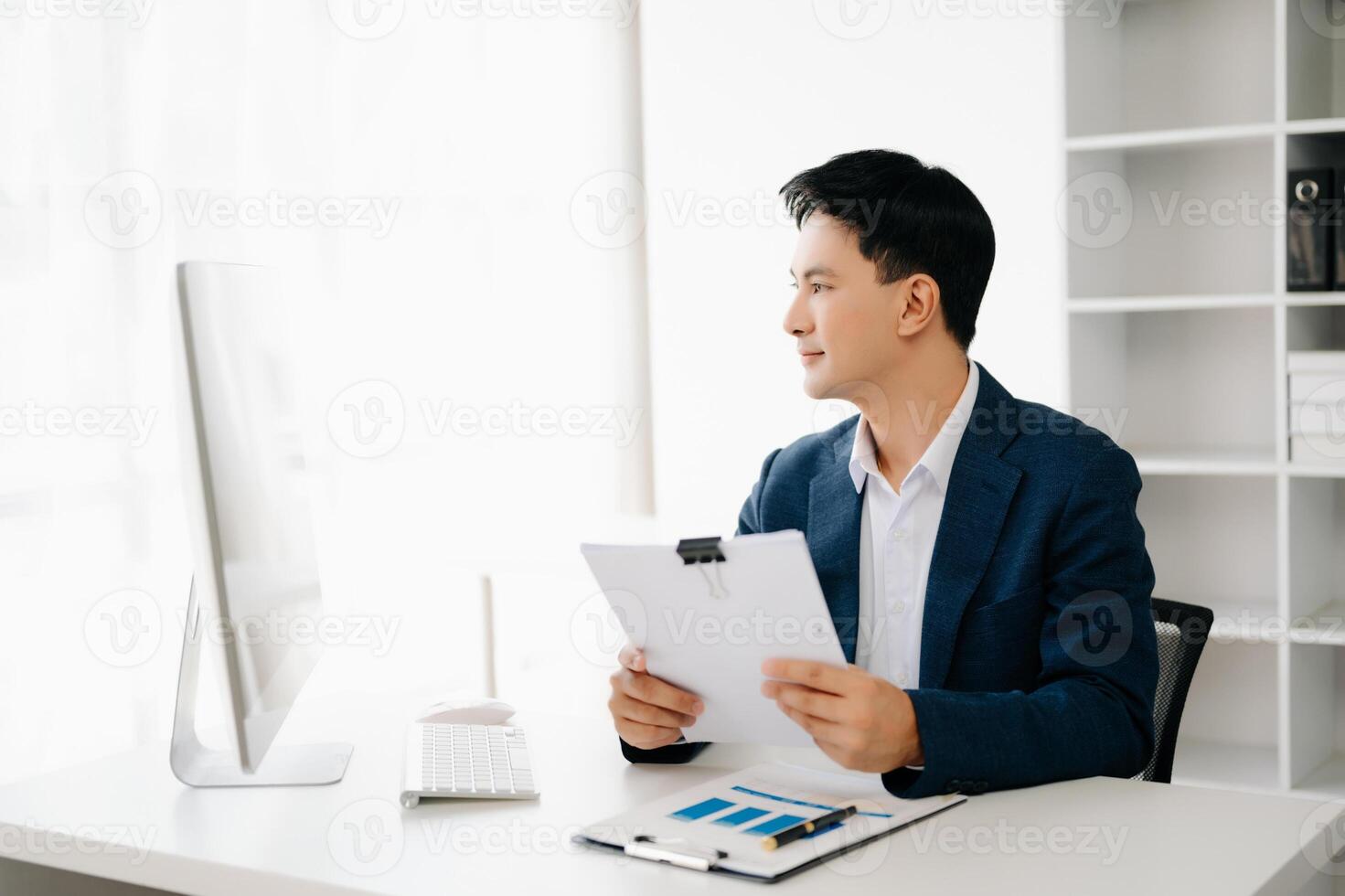 Business man using tablet and laptop for doing math finance on an office desk, tax, report, accounting, statistics, and analytical research concept in office photo