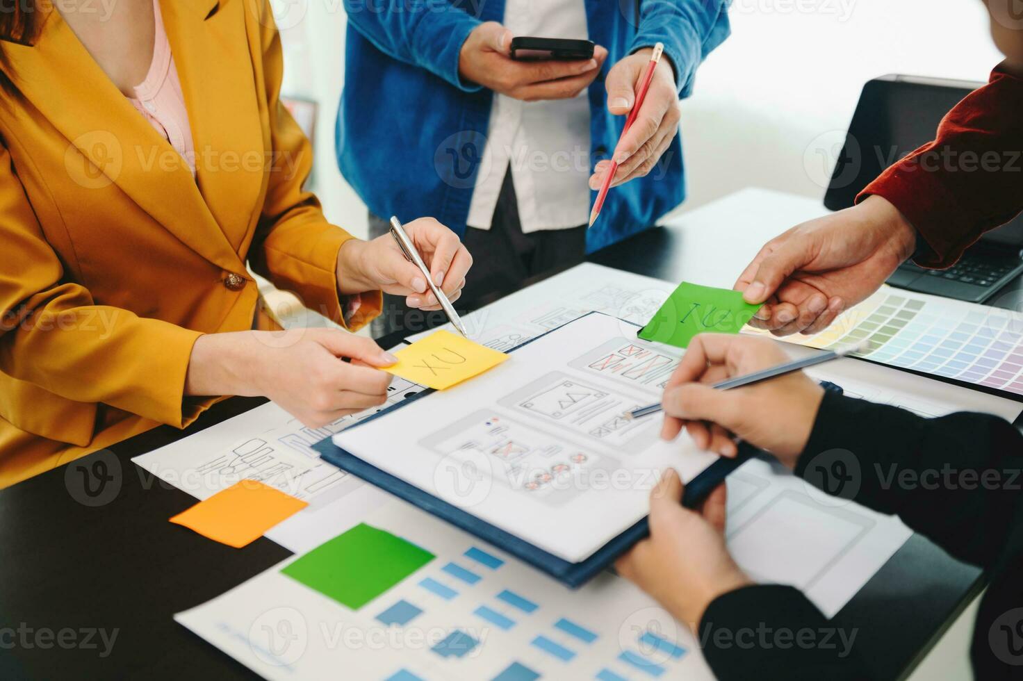 UX developer and ui designer brainstorming about mobile app interface wireframe design with customer breif and color code at office. photo