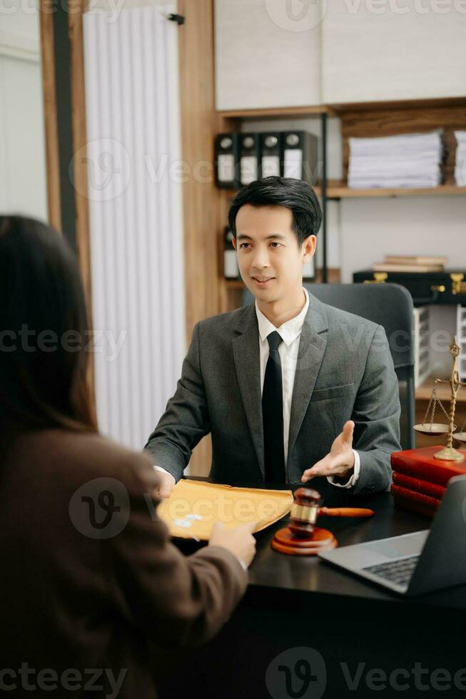 Asian Business law concept, Lawyer business lawyers are consulting lawyers for women entrepreneurs to file copyright lawsuit with laptop and tablet at office photo