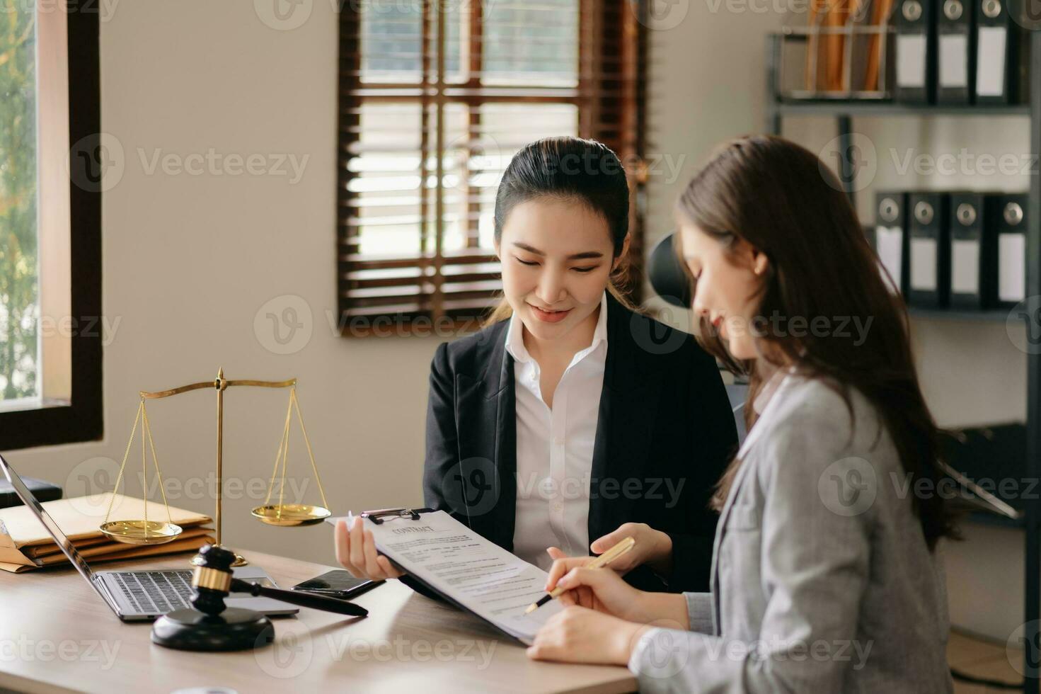 Judge gavel with scales of justice, Business and lawyer or counselor consulting and discussing contract papers with laptop and tablet at law firm in office. photo