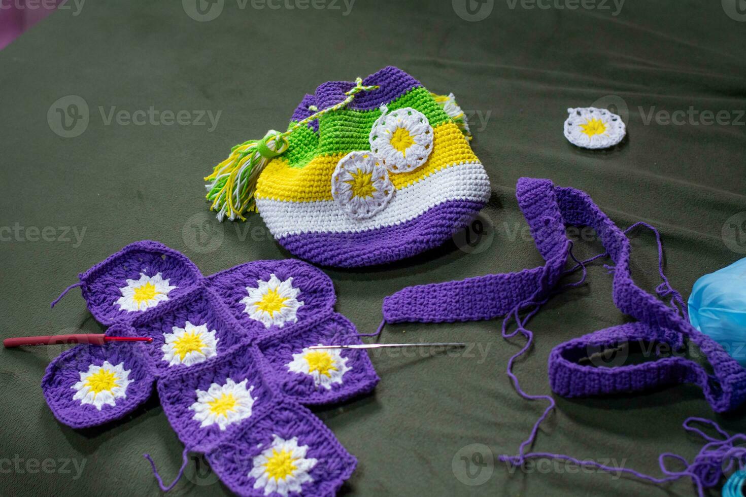 Crochet accessories with koche, using multi-colored threads, handicrafts, on green velvet. photo
