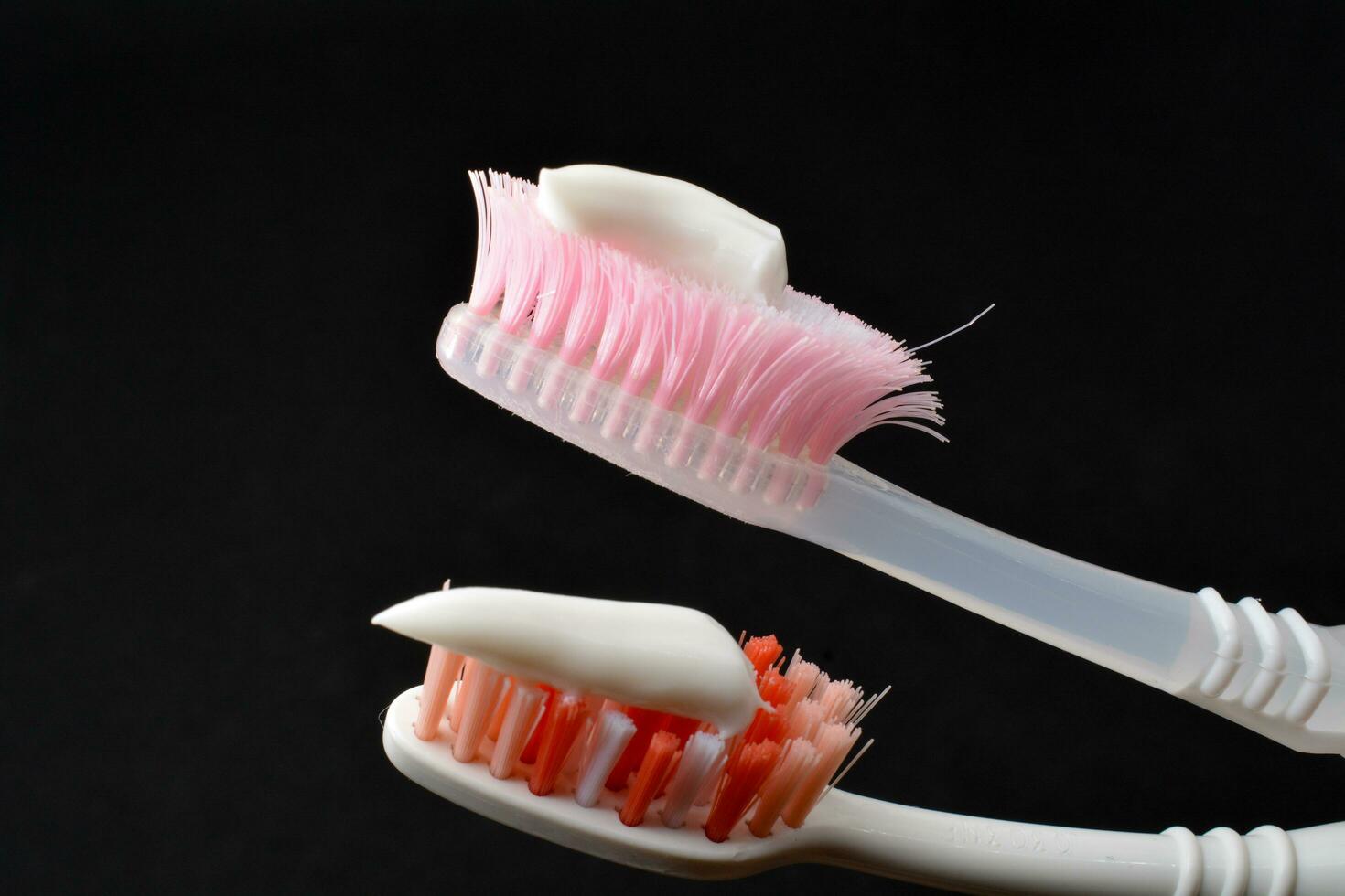 White toothpaste on a toothbrush. Black background photo