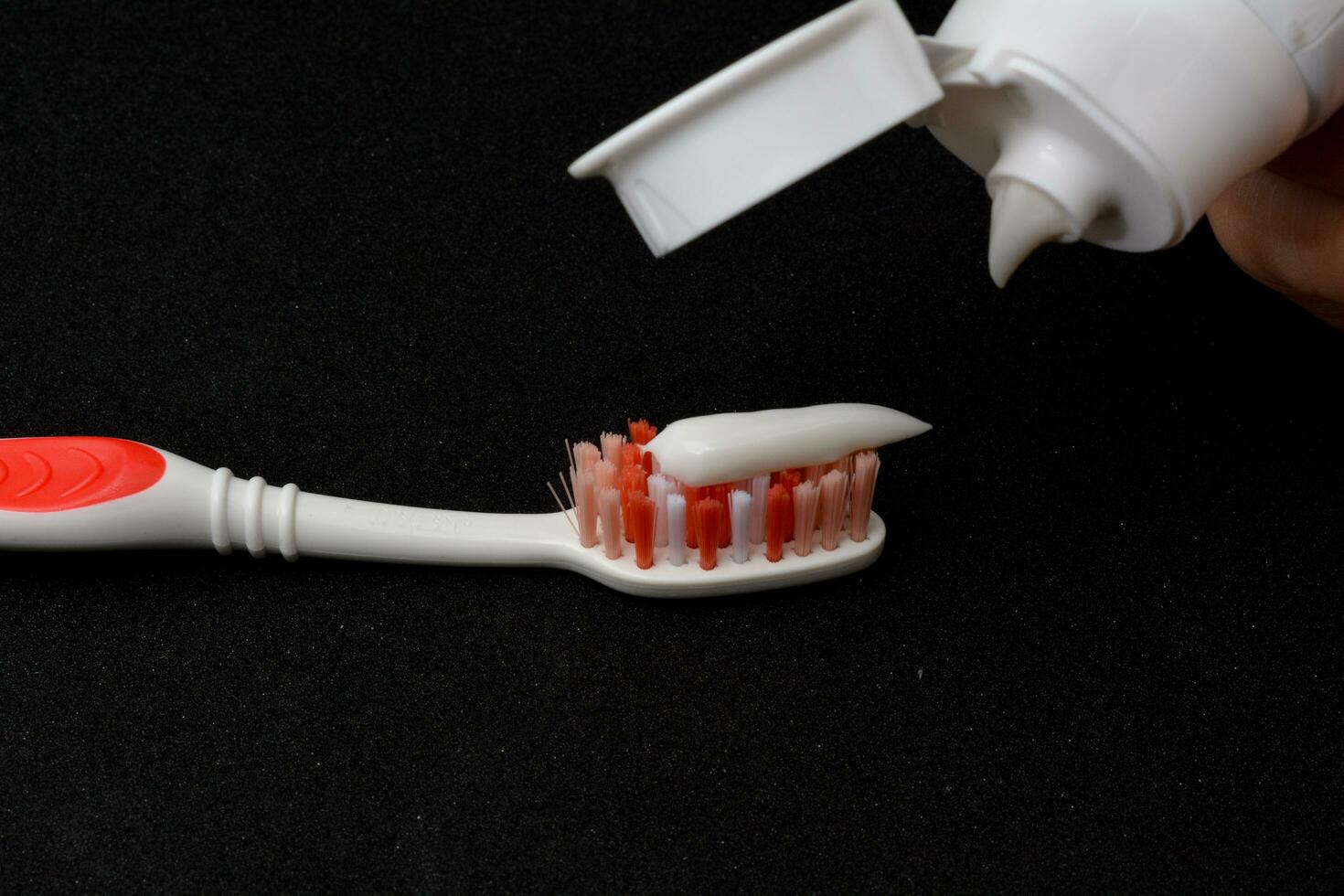 White toothpaste on a toothbrush. Black background photo