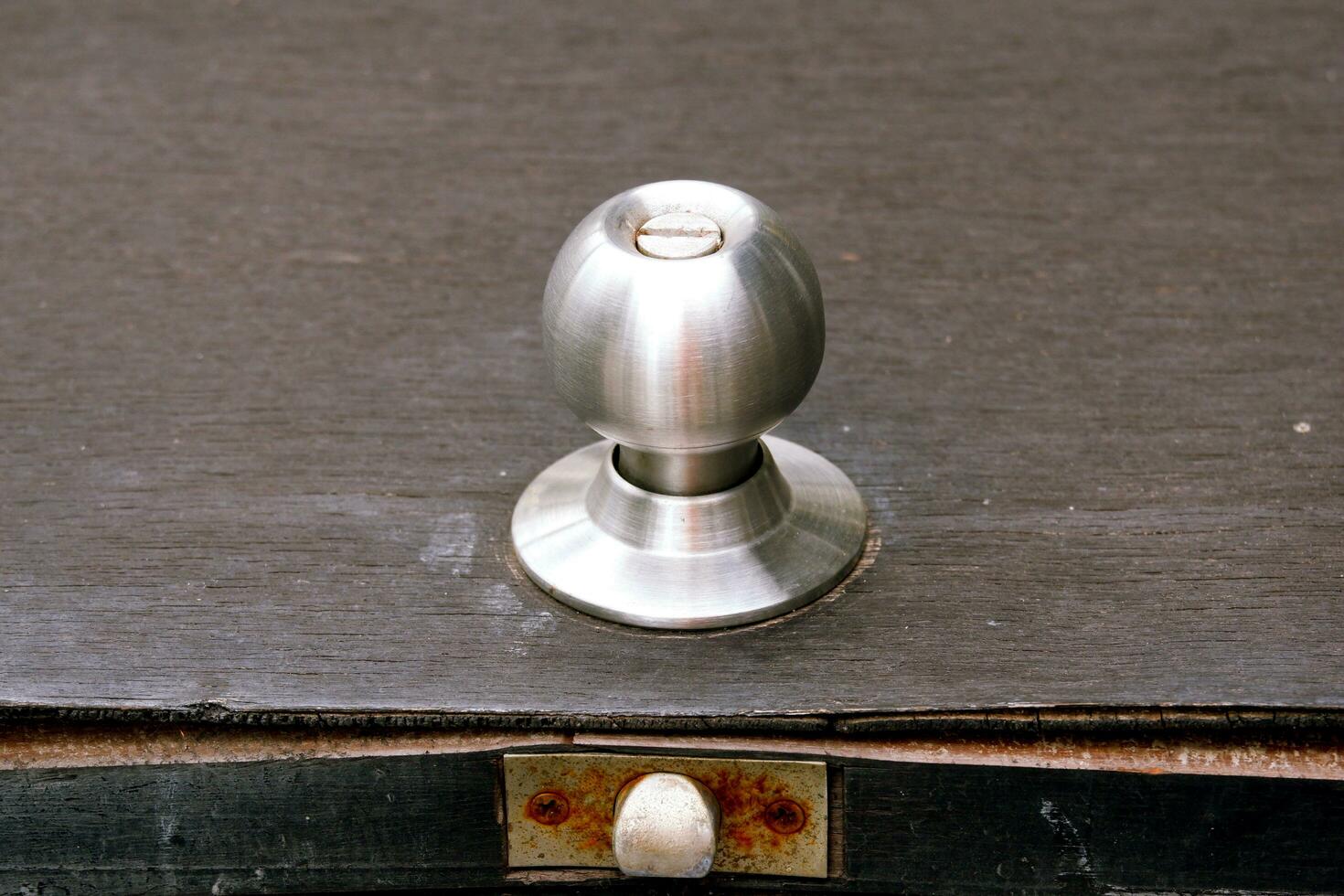 Stainless steel knob on damaged plywood door photo