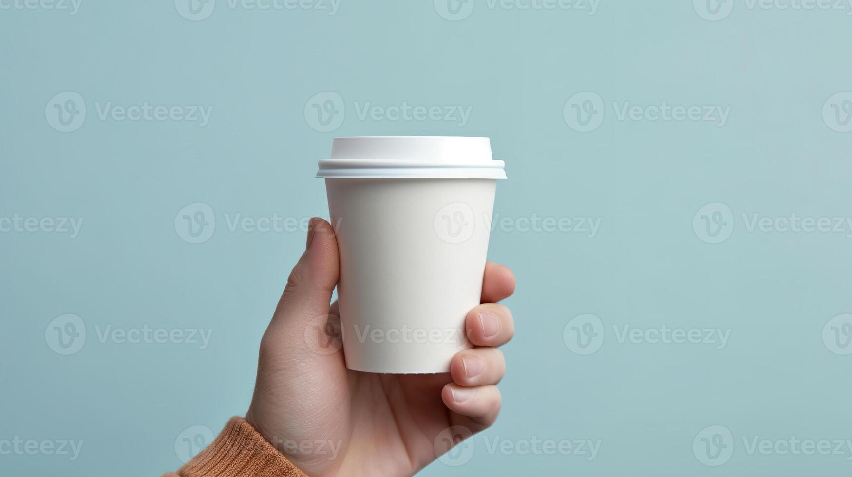 a person holding a coffee cup in their hand close up. photo