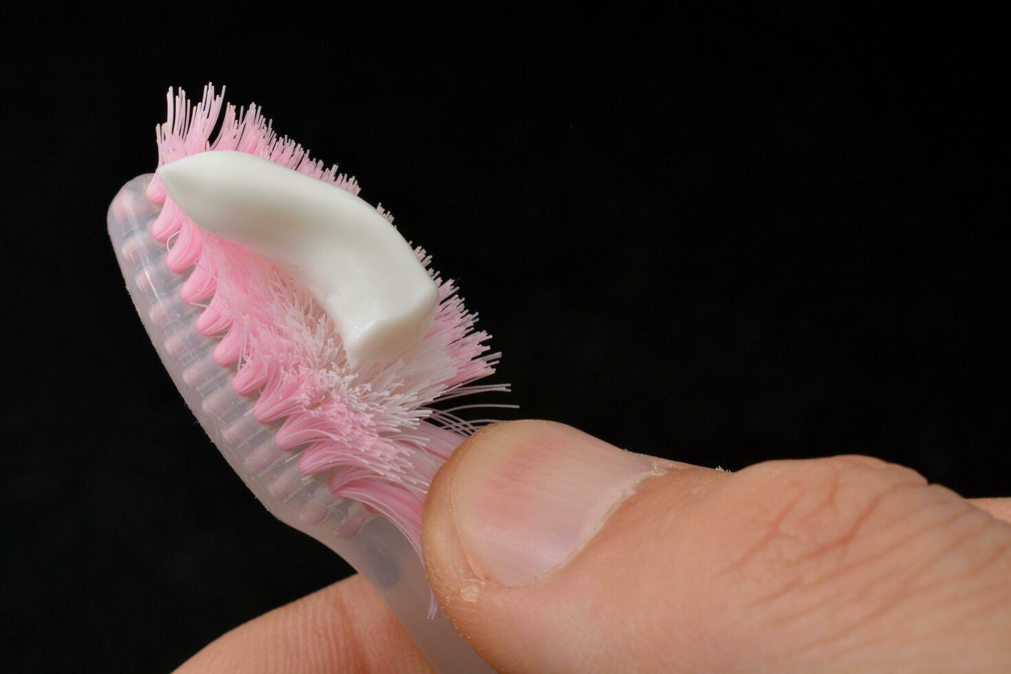 White toothpaste on a toothbrush. Black background photo