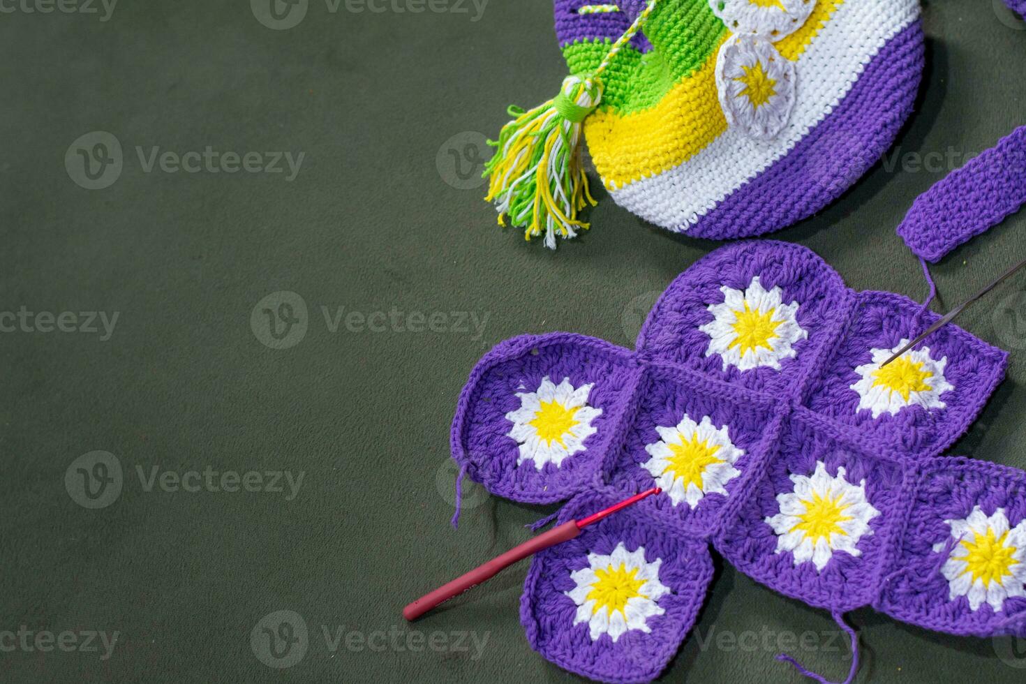 Crochet accessories with koche, using multi-colored threads, handicrafts, on green velvet. photo