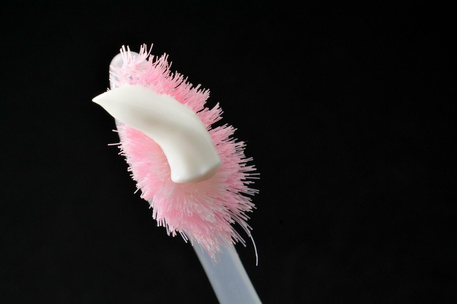 White toothpaste on a toothbrush. Black background photo