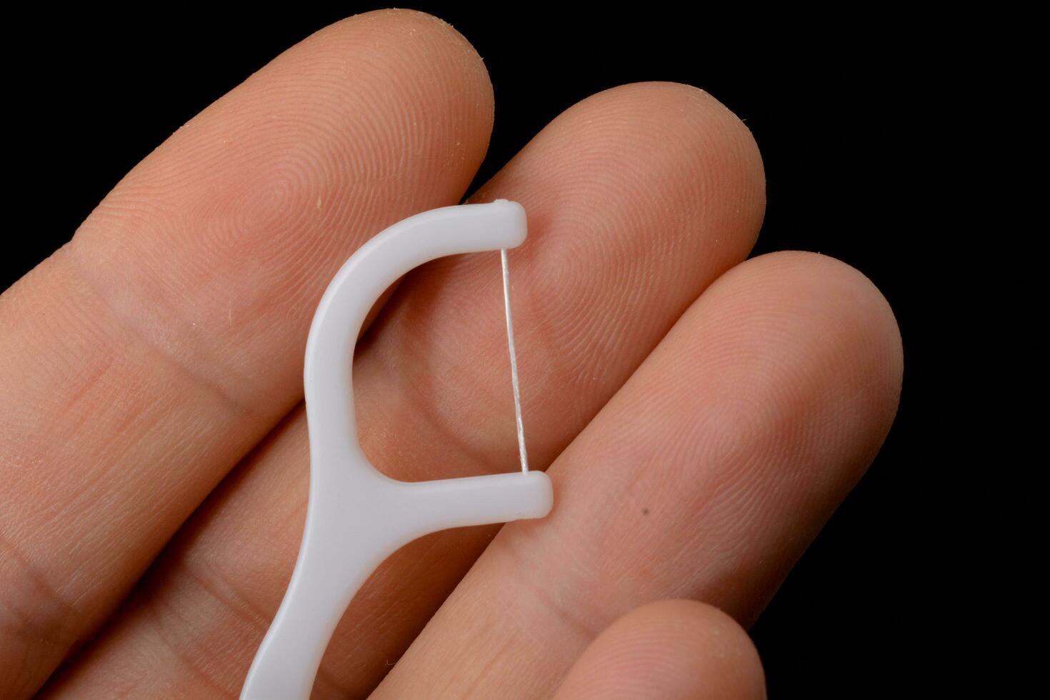 dental floss with pick, white, black background photo