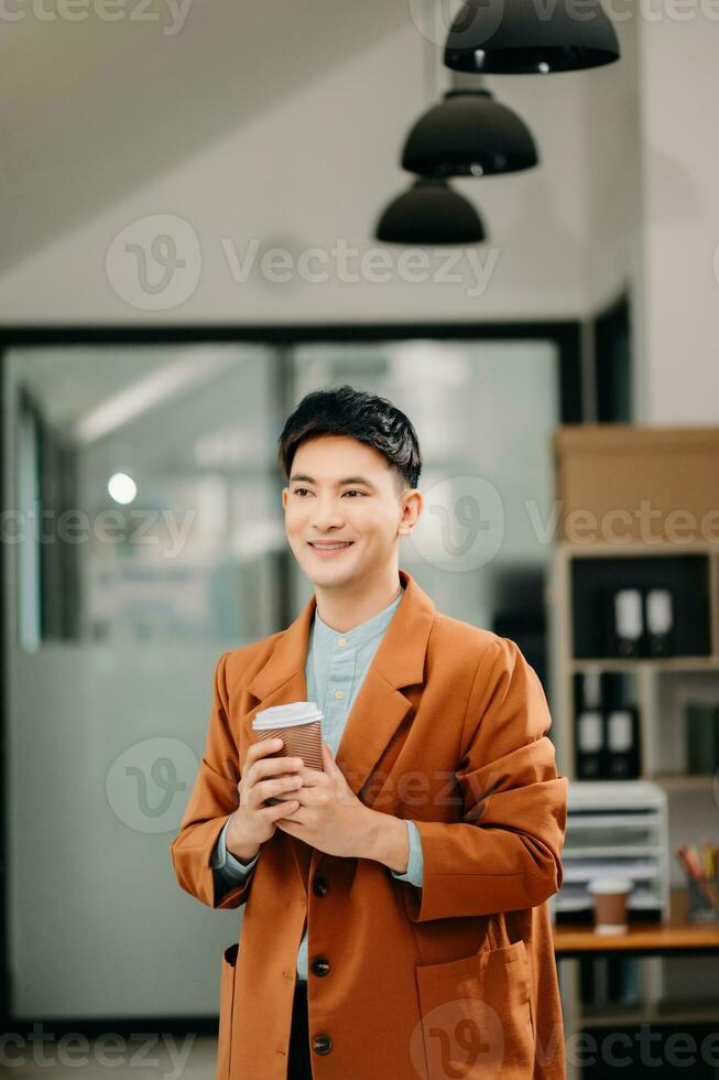 Young attractive Asian male office worker business suits smiling at camera in office photo