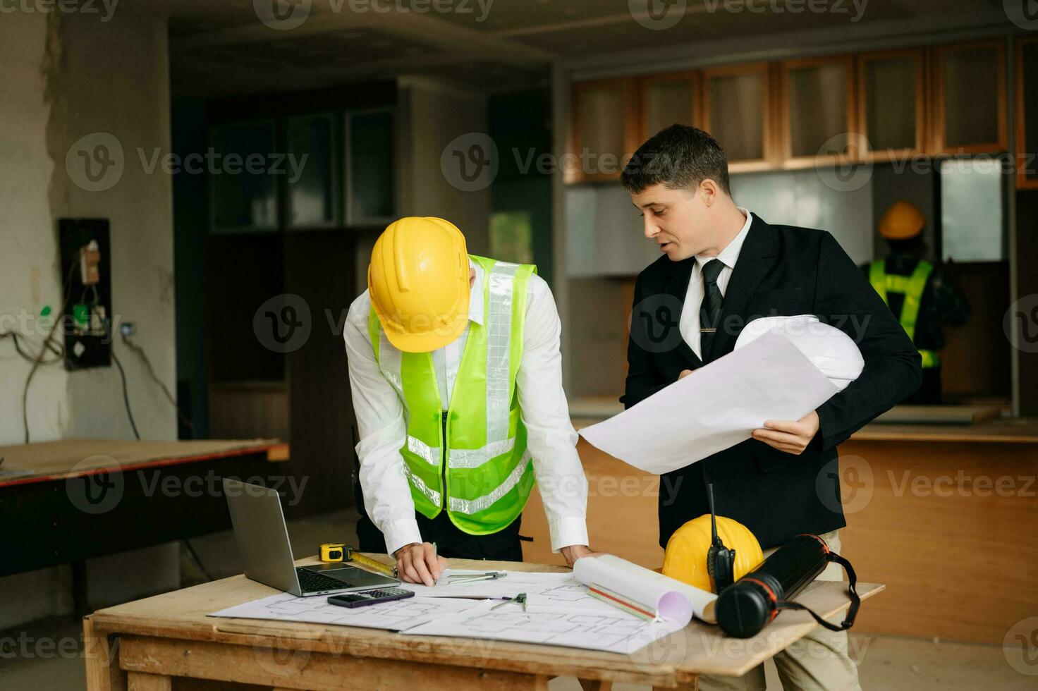 Engineers are discussing data working and laptop or tablet with architectural project at new construction site on big project. interior photo